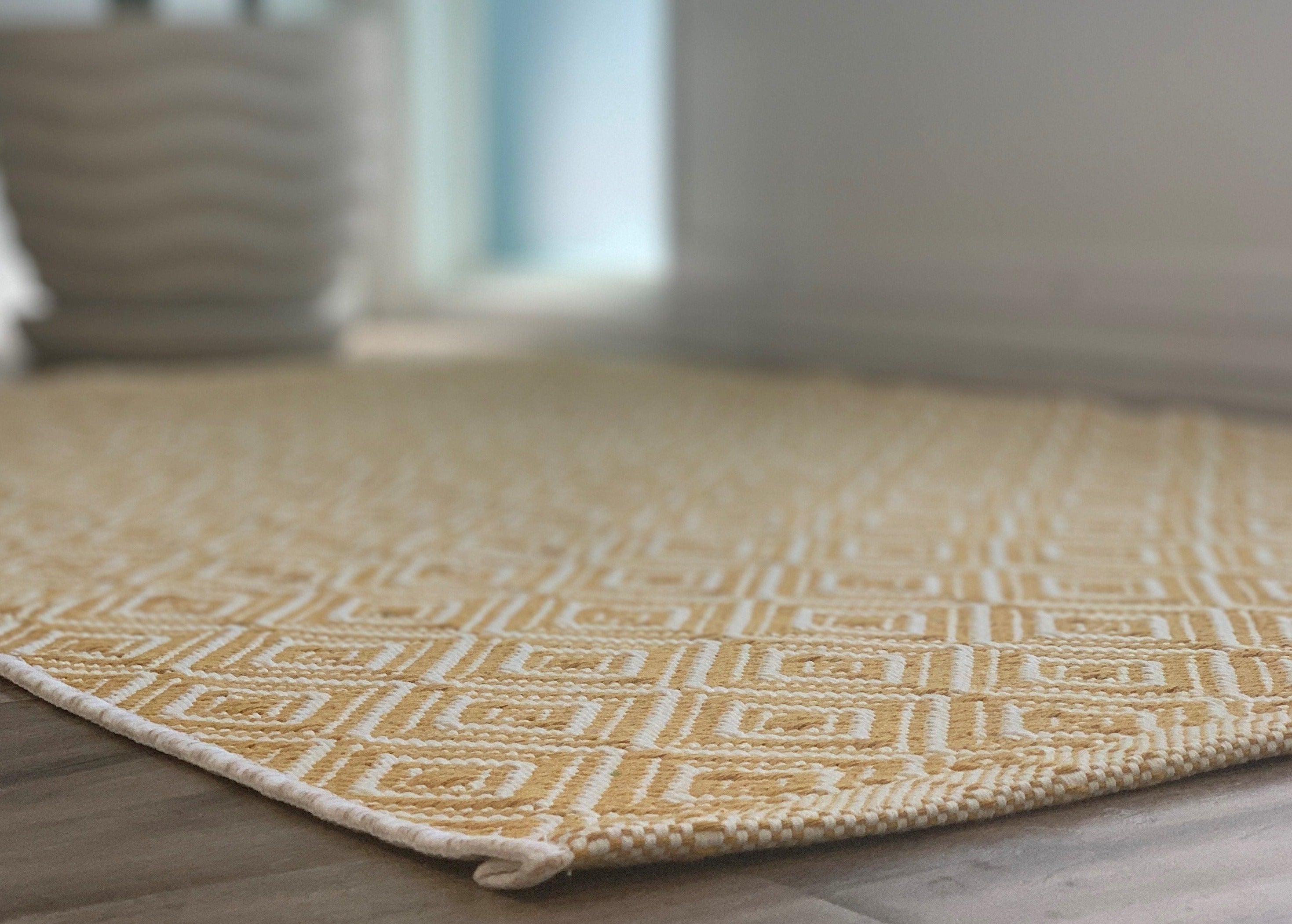 https://nickel-designs.com/cdn/shop/products/rug-boho-woven-doormat-layering-rug-mustard-3@2x.jpg?v=1624307229